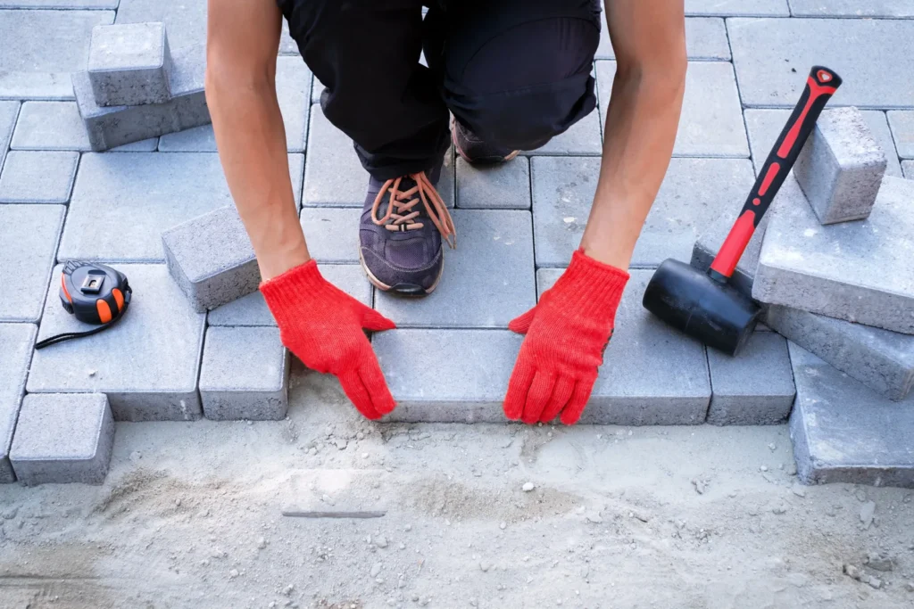Pose de pavés béton en appareillage décalé sur lit de sable stabilisé