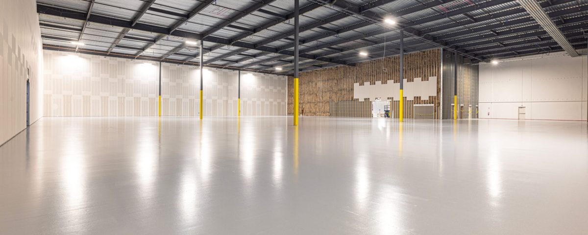 Intérieur d'usine rénové dans l'Eure : sol résine et charpente métallique